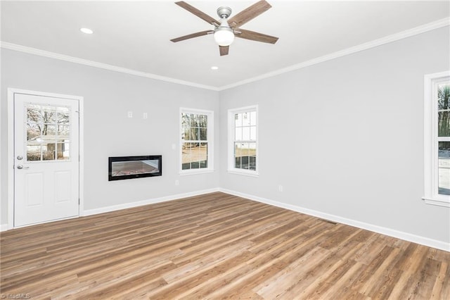 unfurnished living room with ceiling fan, ornamental molding, and wood-type flooring