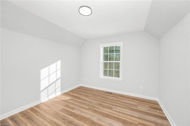 bonus room featuring lofted ceiling and light hardwood / wood-style flooring