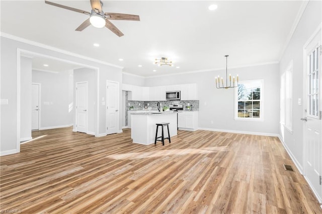 unfurnished living room with ceiling fan with notable chandelier, light hardwood / wood-style floors, crown molding, and sink