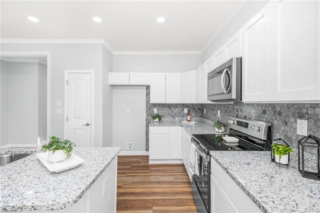 kitchen with light stone counters, stainless steel appliances, white cabinets, and dark hardwood / wood-style floors