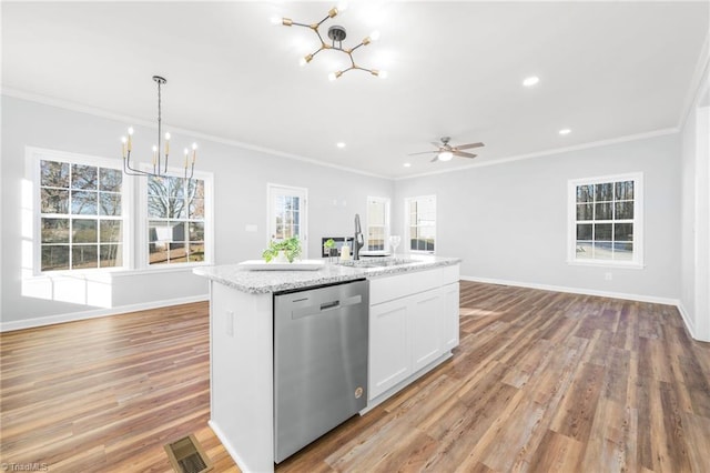 kitchen with decorative light fixtures, white cabinetry, an island with sink, stainless steel dishwasher, and ceiling fan with notable chandelier