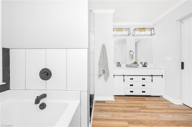 bathroom featuring wood-type flooring, vanity, crown molding, and a bath