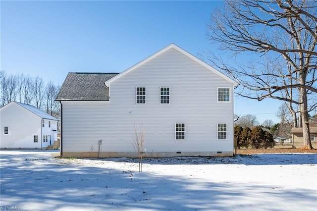 view of snow covered rear of property