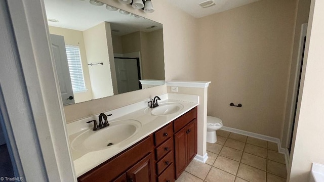 bathroom featuring tile patterned floors, vanity, toilet, and an enclosed shower