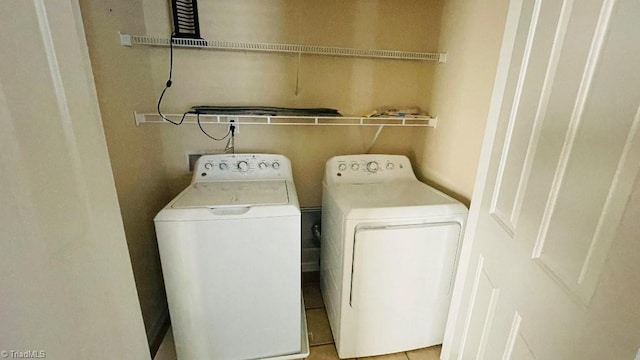 laundry area featuring washer and dryer and light tile patterned flooring