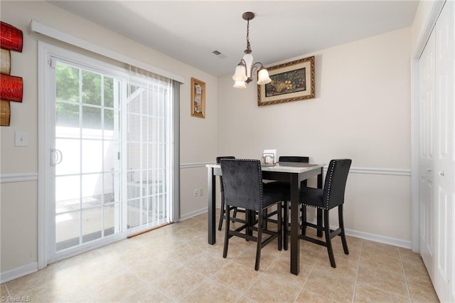 dining area featuring baseboards, a chandelier, and visible vents
