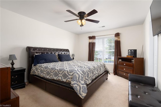 bedroom with light colored carpet, ceiling fan, and visible vents