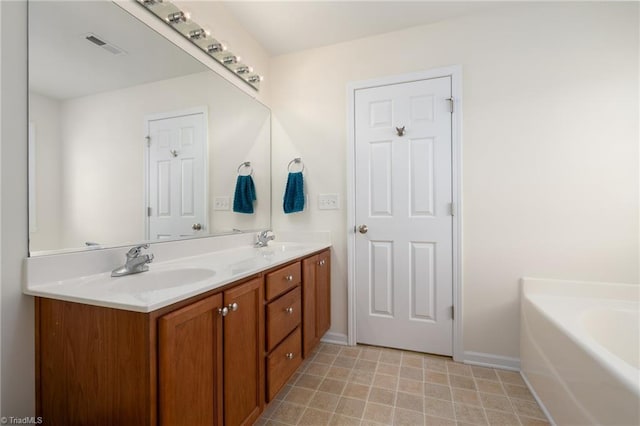bathroom featuring double vanity, baseboards, visible vents, and a sink