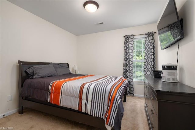 bedroom with baseboards, light colored carpet, and visible vents