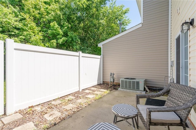 view of patio / terrace with central air condition unit and fence