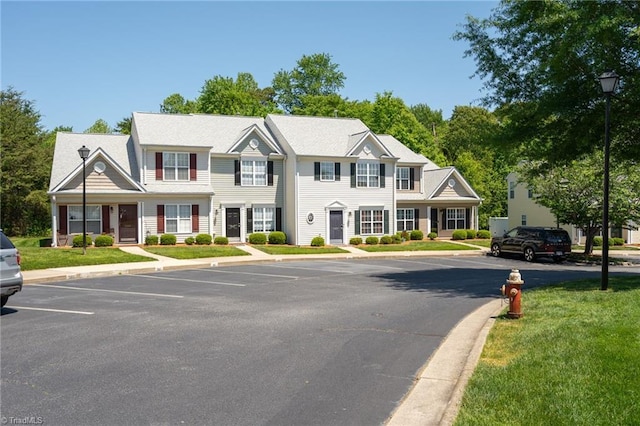 colonial house with uncovered parking and a front yard
