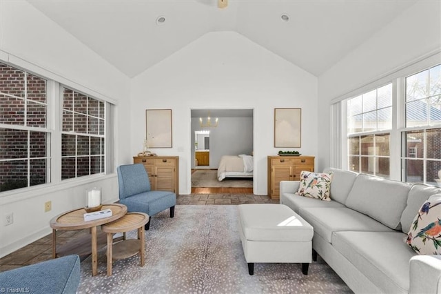 living room with a notable chandelier and vaulted ceiling