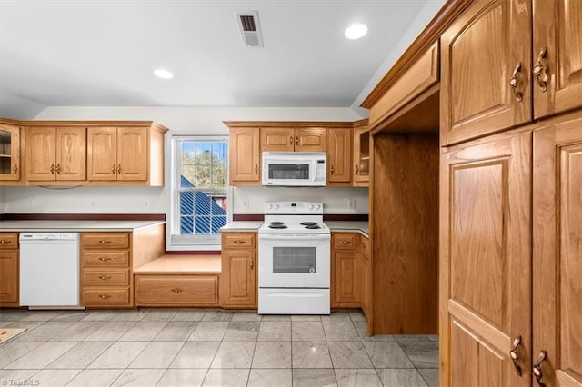 kitchen featuring recessed lighting, white appliances, visible vents, glass insert cabinets, and brown cabinets