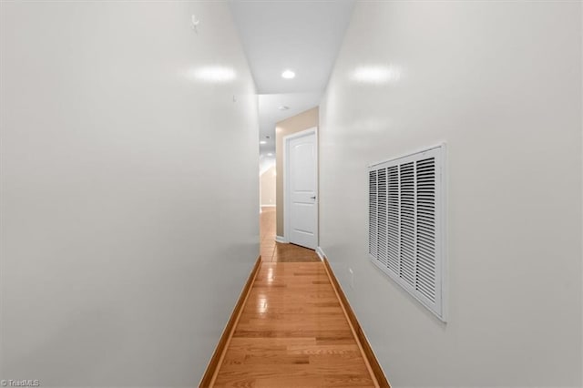 hall with baseboards, visible vents, light wood-style floors, and recessed lighting