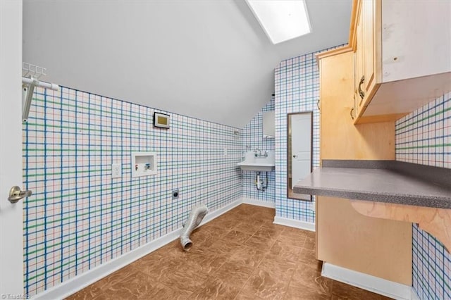 interior space featuring baseboards, tile walls, and vaulted ceiling