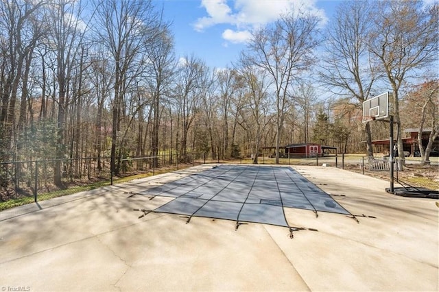 view of pool with a covered pool, fence, and a patio