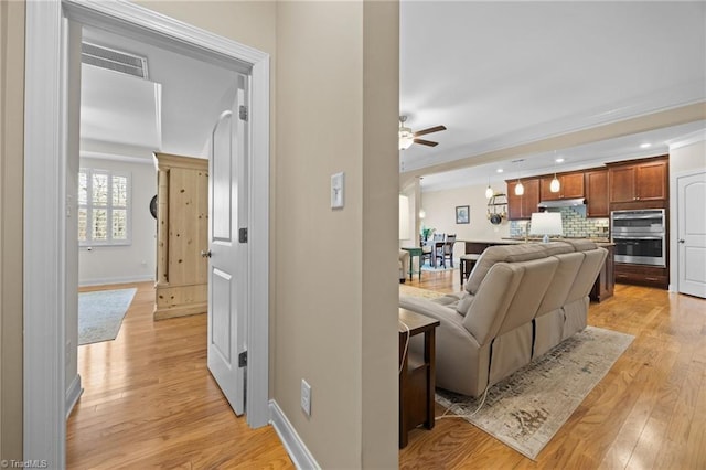 living area with recessed lighting, baseboards, light wood-style floors, and ceiling fan