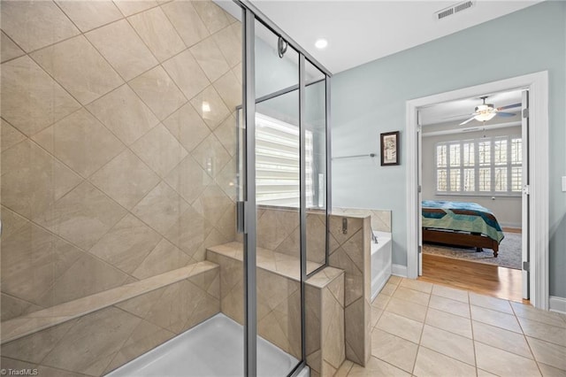 ensuite bathroom featuring tile patterned floors, visible vents, a ceiling fan, ensuite bath, and a shower stall