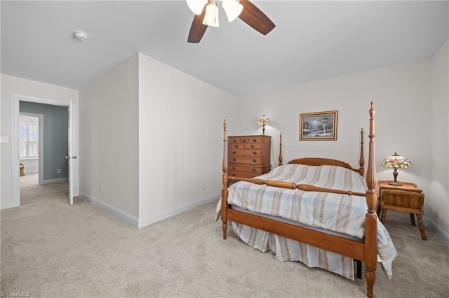 bedroom with baseboards, light colored carpet, and a ceiling fan