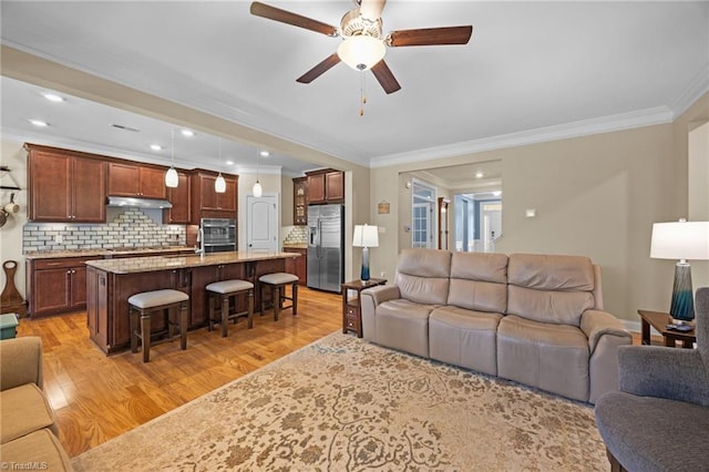 living area featuring ceiling fan, light wood-style flooring, recessed lighting, and ornamental molding