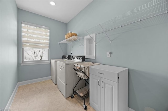 washroom featuring baseboards, separate washer and dryer, and laundry area