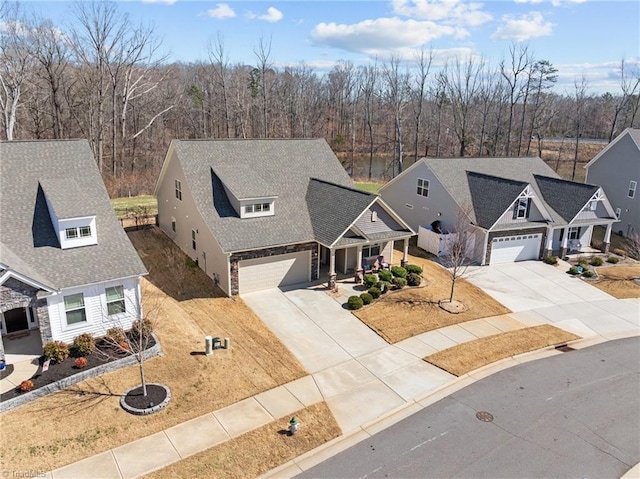 view of front facade with a garage, driveway, and a shingled roof