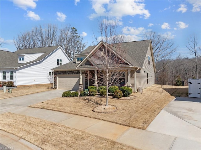 craftsman-style house with a garage, driveway, and roof with shingles