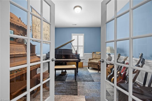 office area featuring a decorative wall, wainscoting, and french doors