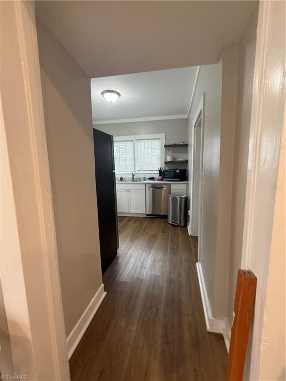 hall with ornamental molding, dark wood-type flooring, and sink