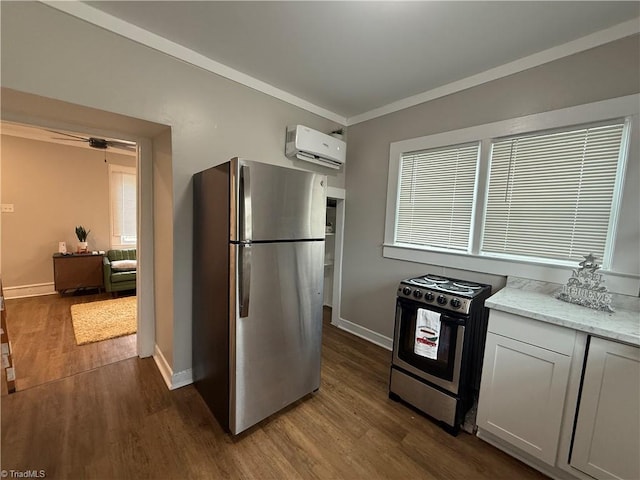 kitchen with white cabinetry, an AC wall unit, range with electric cooktop, and stainless steel refrigerator