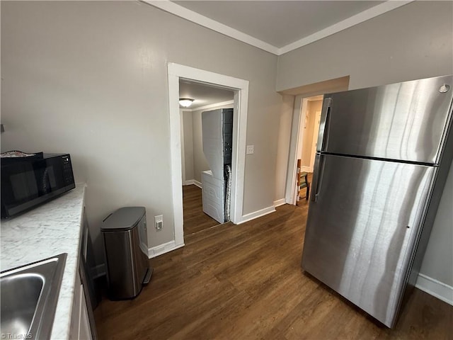 kitchen featuring ornamental molding, sink, stainless steel fridge, and dark hardwood / wood-style flooring