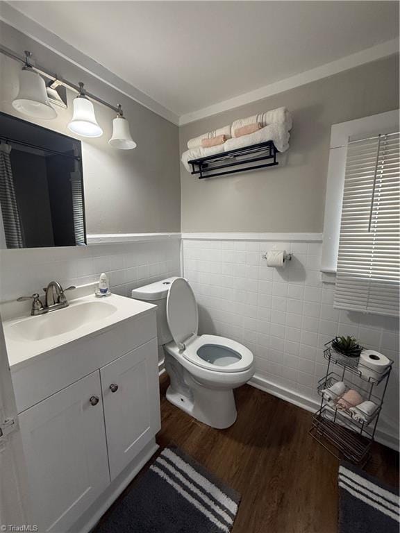 bathroom featuring vanity, wood-type flooring, tile walls, and toilet