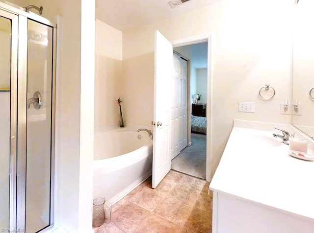 bathroom featuring ensuite bath, a shower stall, a bath, and vanity