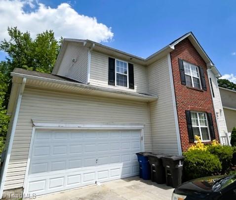 view of front of property featuring driveway and brick siding