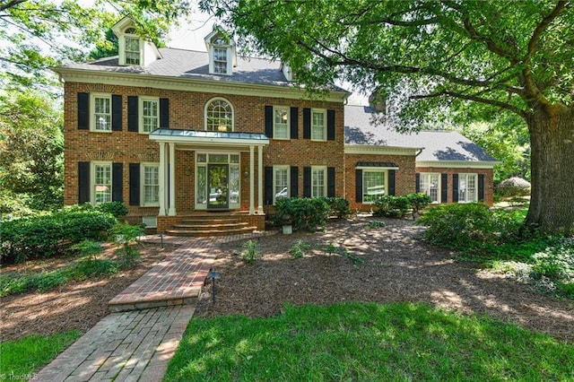 colonial house featuring brick siding