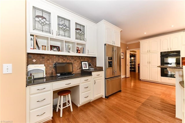 office space with recessed lighting, light wood-type flooring, ornamental molding, and built in desk