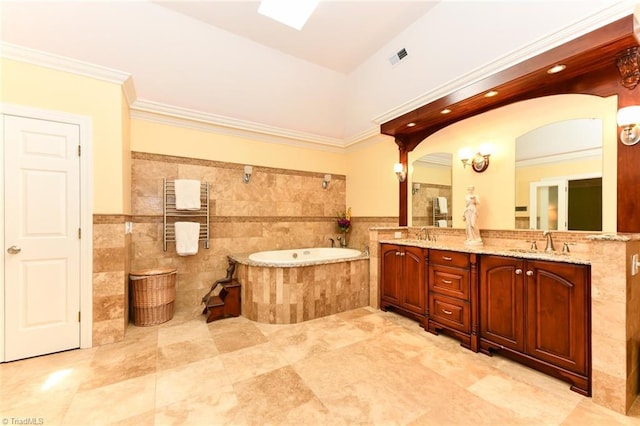 bathroom with ornamental molding, a sink, tile walls, double vanity, and a bath