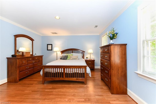 bedroom with visible vents, baseboards, light wood-type flooring, and ornamental molding