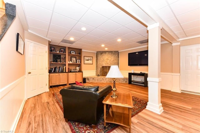 living room featuring recessed lighting, a drop ceiling, light wood-style floors, wainscoting, and crown molding