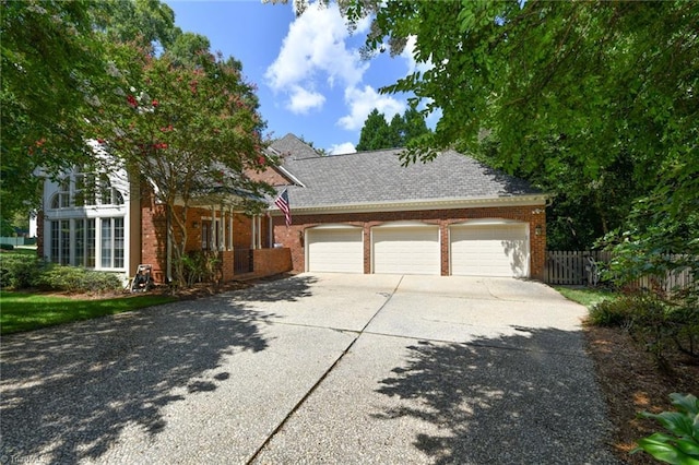 view of front of home featuring brick siding, concrete driveway, an attached garage, and fence