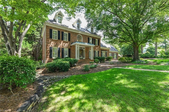 colonial-style house with brick siding and a front yard