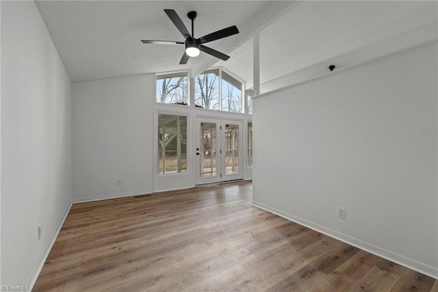 unfurnished living room with hardwood / wood-style flooring, ceiling fan, high vaulted ceiling, and beamed ceiling