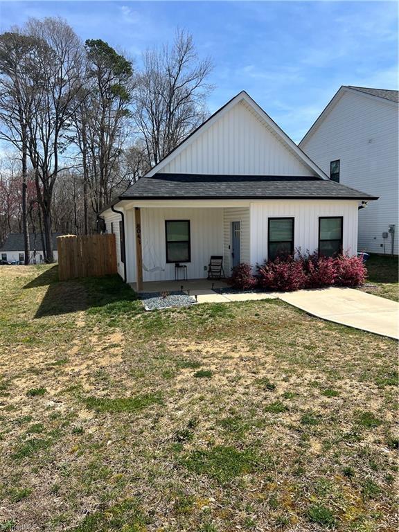 view of front facade with a patio, a front lawn, and fence