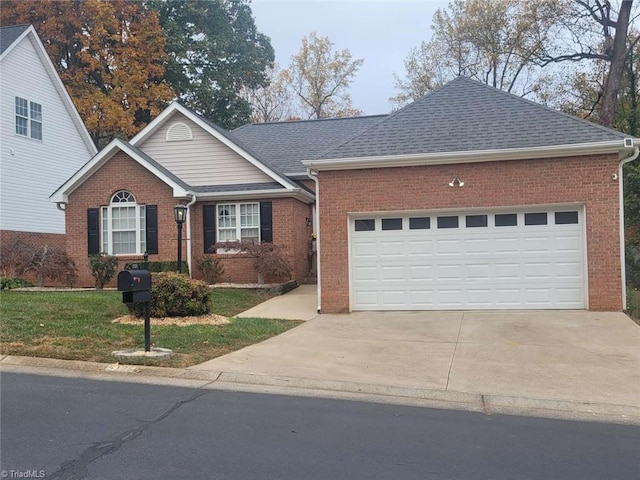 5125 Old Plantation Cir, Winston-Salem, NC 27104 - view of front of home with brick siding, driveway, an attached garage, a front yard, and roof with shingles