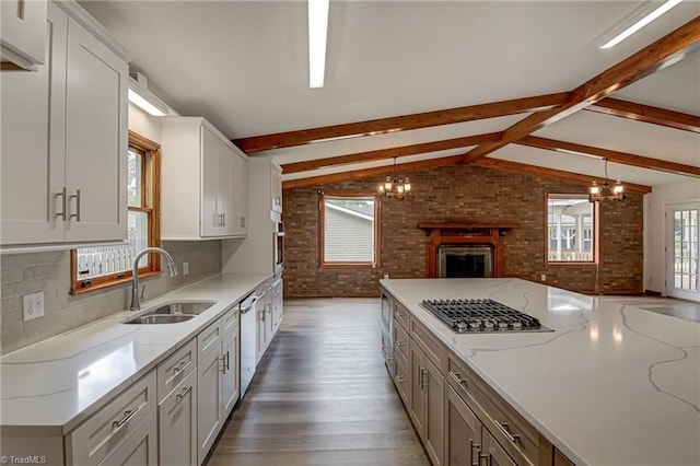 210 W Parkway Ave, High Point, NC 27284 - kitchen with a sink, appliances with stainless steel finishes, brick wall, open floor plan, and wood finished floors