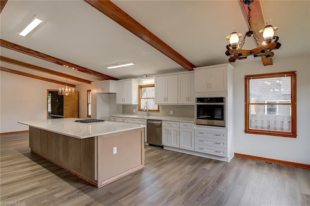 210 W Parkway Ave, High Point, NC 27284 - kitchen featuring a chandelier, stainless steel appliances, a sink, beamed ceiling, and white cabinets