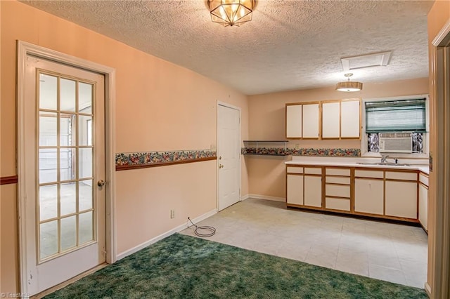 210 W Parkway Ave, High Point, NC 27284 - kitchen featuring a sink, a textured ceiling, light countertops, baseboards, and cooling unit