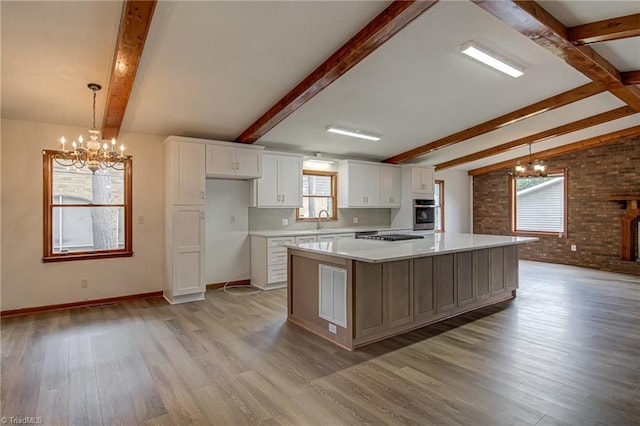 210 W Parkway Ave, High Point, NC 27284 - kitchen with a chandelier, appliances with stainless steel finishes, a sink, beam ceiling, and light wood-style flooring
