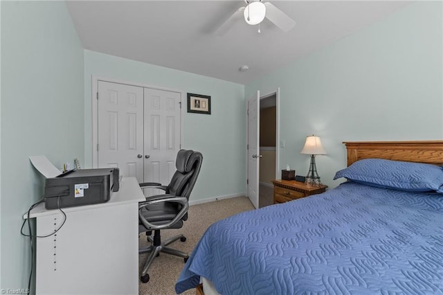bedroom with a closet, baseboards, light carpet, and a ceiling fan