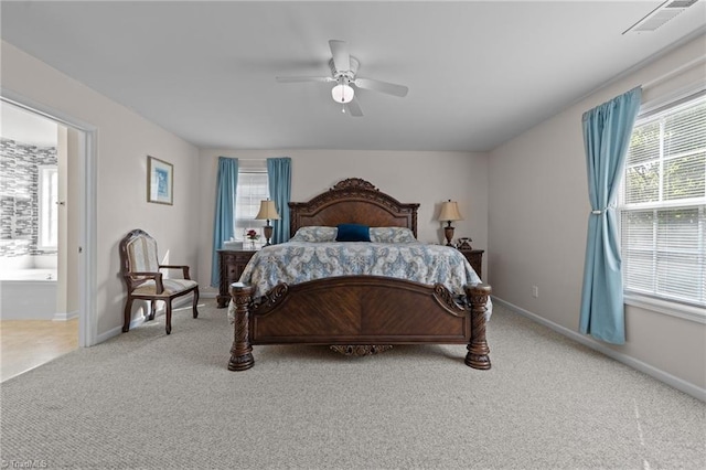 carpeted bedroom featuring baseboards, ceiling fan, connected bathroom, and visible vents